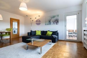 uma sala de estar com um sofá preto e uma mesa em 3 Zimmer Familienwohnung mit WLAN & Netflix em Mönchengladbach