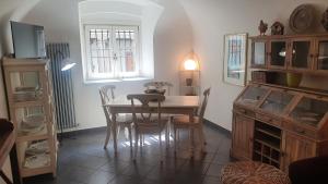Un comedor con mesa y sillas y una ventana. en Angels Home Città Alta, en Bérgamo