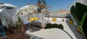 1 cama con almohadas amarillas en el balcón en CASA ZOUINA, en Agadir