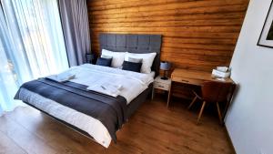 1 dormitorio con 1 cama y pared de madera en Monte Amnis Apartment, en Tatranská Štrba