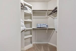 a walk in closet with white walls and shelves at 1 BR Modern Escape Mins fromTX Med Center FREE Parking in Houston