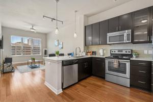 a kitchen with stainless steel appliances and black cabinets at 1 BR Modern Escape Mins fromTX Med Center FREE Parking in Houston
