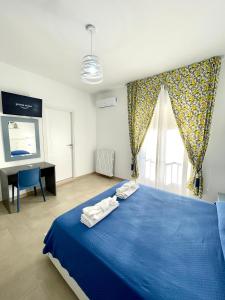 um quarto com uma cama azul com duas toalhas em B&B Marconi em Ricadi