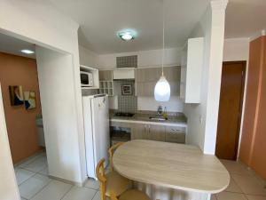 een kleine keuken met een tafel en een koelkast bij Riviera Park Flat Charme in Caldas Novas