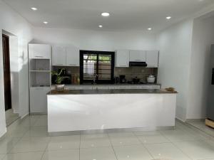 a large white kitchen with a large counter top at Villa d'exception à 20 min de l'aéroport 