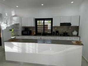 a kitchen with white cabinets and a counter top at Villa d'exception à 20 min de l'aéroport 