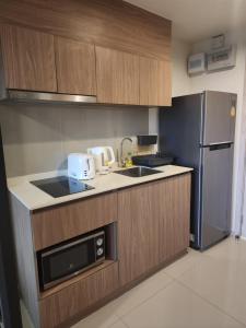 a kitchen with a sink and a refrigerator at Apple's La casita condo Hua Hin room2 in Hua Hin