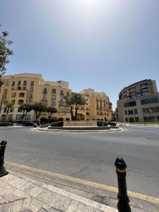 an empty street in front of a large building at St Julians Aptartment 2 in St Julian's