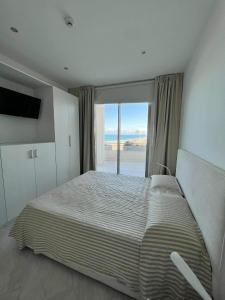 a bedroom with a large bed with a large window at Ascensore per la spiaggia in Cirella