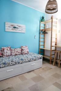 a bedroom with a bed and a blue wall at Casa VersoMare Rooftop in Gagliano del Capo