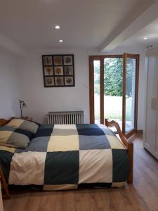 1 dormitorio con 1 cama con edredón blanco y negro en Bel appartement rez-de-jardin en Saint-Genest-Malifaux