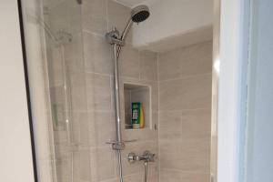 La salle de bains est pourvue d'une douche avec un pommeau de douche. dans l'établissement Bel appartement rez-de-jardin, à Saint-Genest-Malifaux