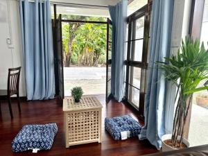 ein Wohnzimmer mit blauen Vorhängen und einer Glasschiebetür in der Unterkunft Sukhumvit villa/花園私密獨棟5房/輕軌步行3分鐘/預定3天送接機服務 in Amphoe Phra Khanong