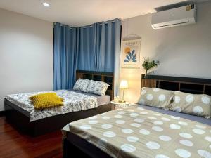 2 Betten in einem Zimmer mit blauen Vorhängen in der Unterkunft Sukhumvit villa/花園私密獨棟5房/輕軌步行3分鐘/預定3天送接機服務 in Amphoe Phra Khanong