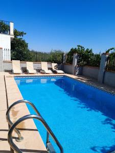 a swimming pool with lounge chairs next to a building at La Laguna in Almedinilla