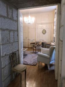 uma sala de estar com cadeiras, uma mesa e um lustre em Appartement Périgueux historique em Périgueux