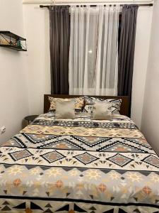 a bed with a quilt on it in a bedroom at Alina Urban Getaway in Novi Sad