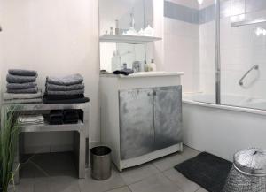 uma casa de banho branca com uma banheira, um chuveiro e toalhas em Appartement Périgueux historique em Périgueux