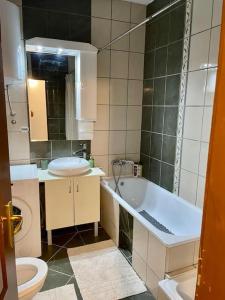 a bathroom with a tub and a toilet and a sink at Alina Urban Getaway in Novi Sad