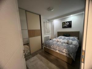 - une petite chambre avec un lit et un miroir dans l'établissement Apartman PANDA deluxe Sarajevo, à Sarajevo