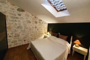 a bedroom with a white bed and a skylight at Comfortable stone house apartment 4 persons Poreč, 4km in Musalez