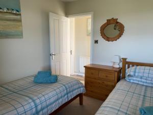 a bedroom with two beds and a mirror on the wall at The Downs, Thurlestone, South Devon, close to several beaches in Kingsbridge
