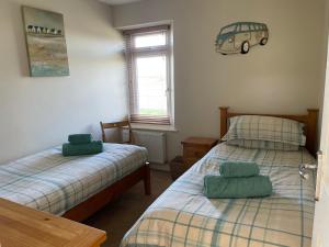 a bedroom with two beds and a car picture on the wall at The Downs, Thurlestone, South Devon, close to several beaches in Kingsbridge