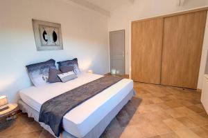 um quarto com uma cama grande e um armário de madeira em Aux trois Cyprès Salernes en Provence em Salernes