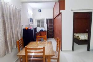 een keuken en eetkamer met een tafel en stoelen bij Servostay Hafeezpet - 2 Bhk Fully Furnished Flat at Ground Floor in Hyderabad