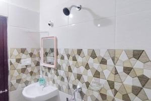 een badkamer met een wastafel en een spiegel bij Servostay Hafeezpet - 2 Bhk Fully Furnished Flat at Ground Floor in Hyderabad