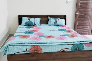 een bed met een blauw en roze dekbed en kussens bij Servostay Hafeezpet - 2 Bhk Fully Furnished Flat at Ground Floor in Hyderabad