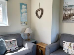a living room with two chairs and a table at The Downs, Thurlestone, South Devon, close to several beaches in Kingsbridge