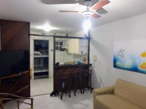 a living room with a couch and a ceiling fan at Casinha no Paraiso in Arraial do Cabo +13 photos