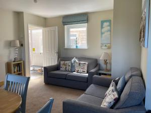 a living room with a couch and a table at The Downs, Thurlestone, South Devon, close to several beaches in Kingsbridge