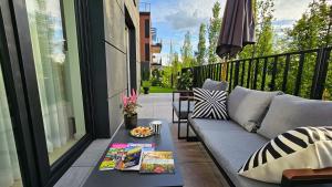 a patio with a couch and a table on a balcony at Apartament Wietrznia z tarasem, ogródkiem, parkingiem, na prestiżowym osiedlu obok rezerwatu przyrody NEW!!! in Kielce