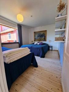 a bedroom with two beds and a large window at Det Gamle Garnbinderi, ved Møns bedste strand. in Borre