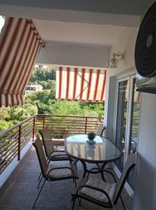 un patio con tavolo e sedie sul balcone. di LOVELY APARTMENT a PalaiónTsiflíkion