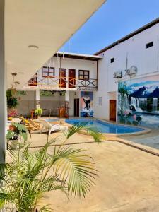 ein Haus mit einem Pool im Hof in der Unterkunft Hostal Laurita Beach in Montañita