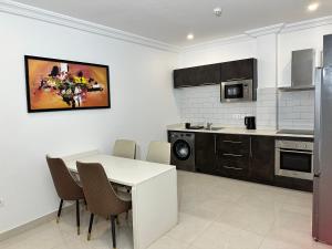 cocina con mesa blanca y sillas en Westlands Tower - Ghana Villas, en Accra