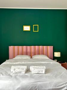 Un dormitorio con una cama grande con una pared verde. en Iris apartament - complex rezidențial, en Timisoara