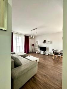 una sala de estar con un sofá y una mesa en Iris apartament - complex rezidențial, en Timisoara
