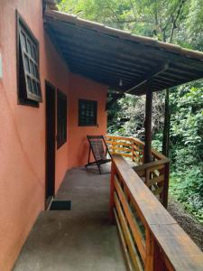 a porch of an orange house with a wooden railing at Pousada Pé da Mata Maresias in Maresias