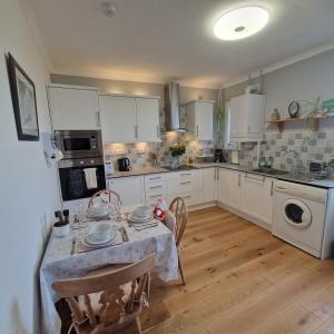 a kitchen with a table and a kitchen with white cabinets at 3 Bedroom Apartment max 5 Pax Musselburgh in Musselburgh