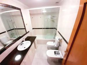 ein Badezimmer mit einem Waschbecken, einem WC und einem Spiegel in der Unterkunft Habitación céntrica en Pamplona in Pamplona