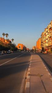 an empty city street with buildings in the background at Luxury apartment Gueliz (2 min walk from Train Station) in Marrakesh