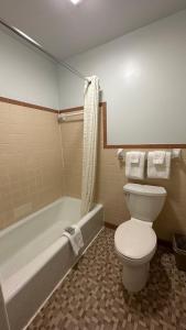 a bathroom with a toilet and a bath tub at Colonial Inn Franklin in Franklin