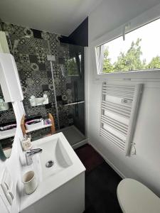La salle de bains est pourvue d'un lavabo blanc et d'une fenêtre. dans l'établissement BLUE BAY, à Mosty