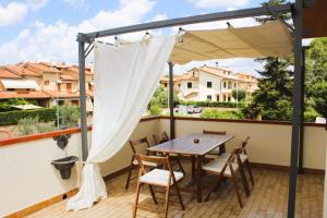 a wooden table and chairs on a balcony with a canopy at Casa Luisa in Pitigliano