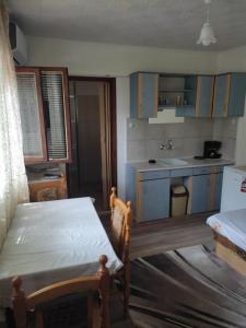 a kitchen with blue cabinets and a table in it at Уют и топлина. in Varna City
