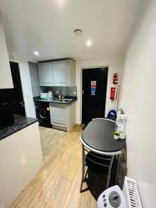 a small kitchen with a table and a counter top at Exclusive Private One Bedroom Suite in London